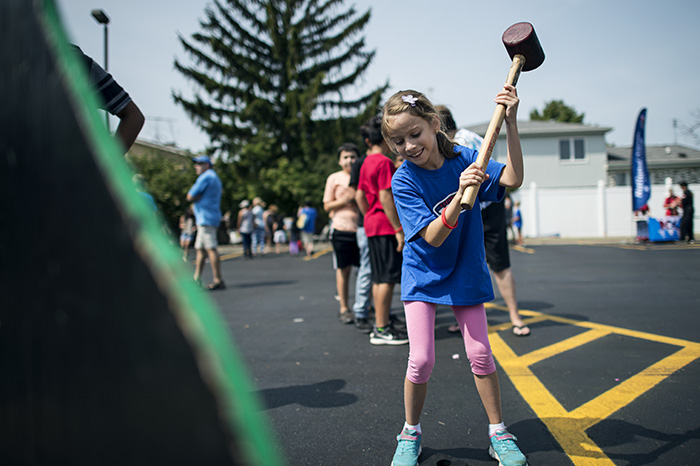 Girl Playing Strength Game with Hammer