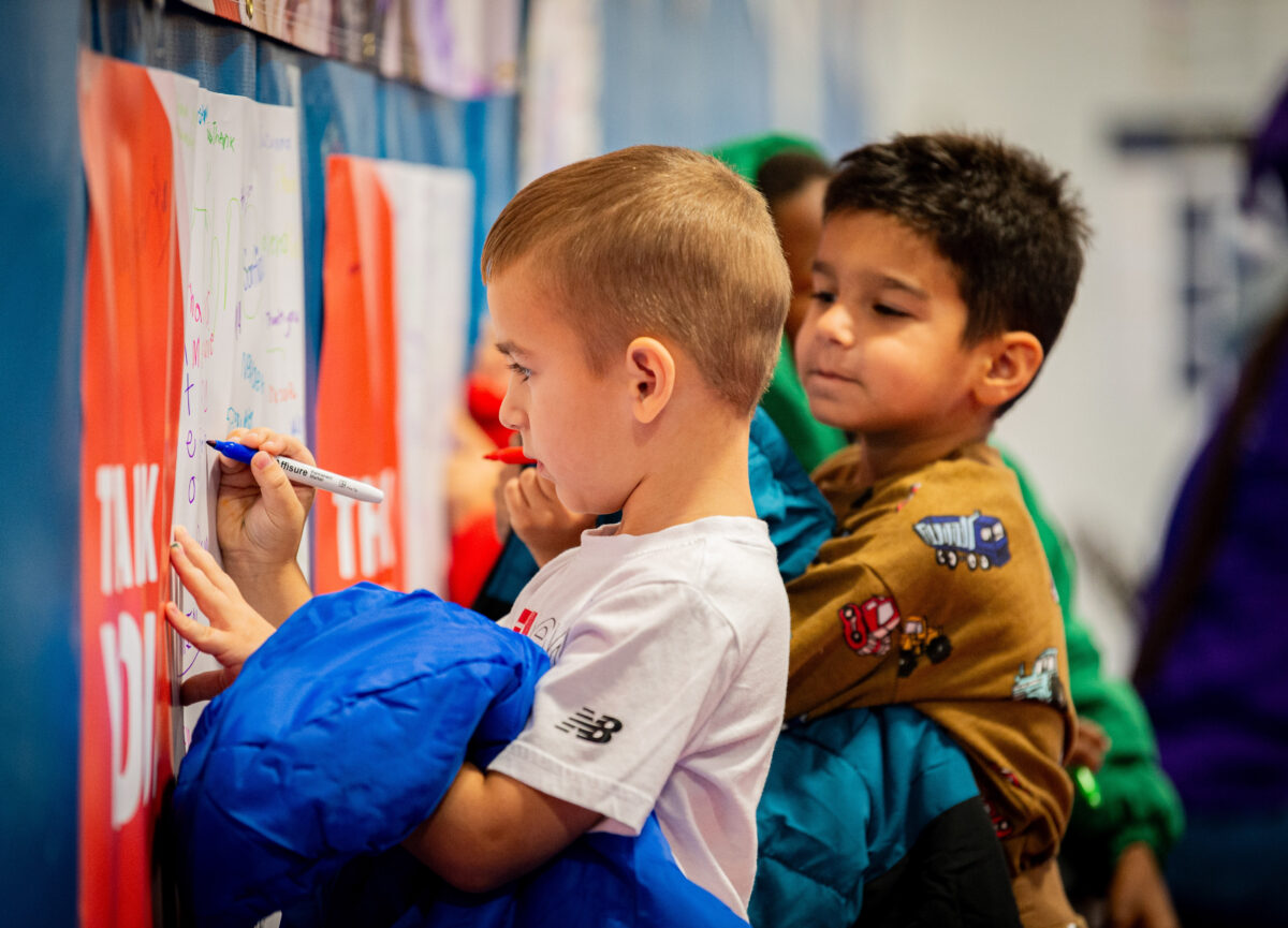 Students writing on sign